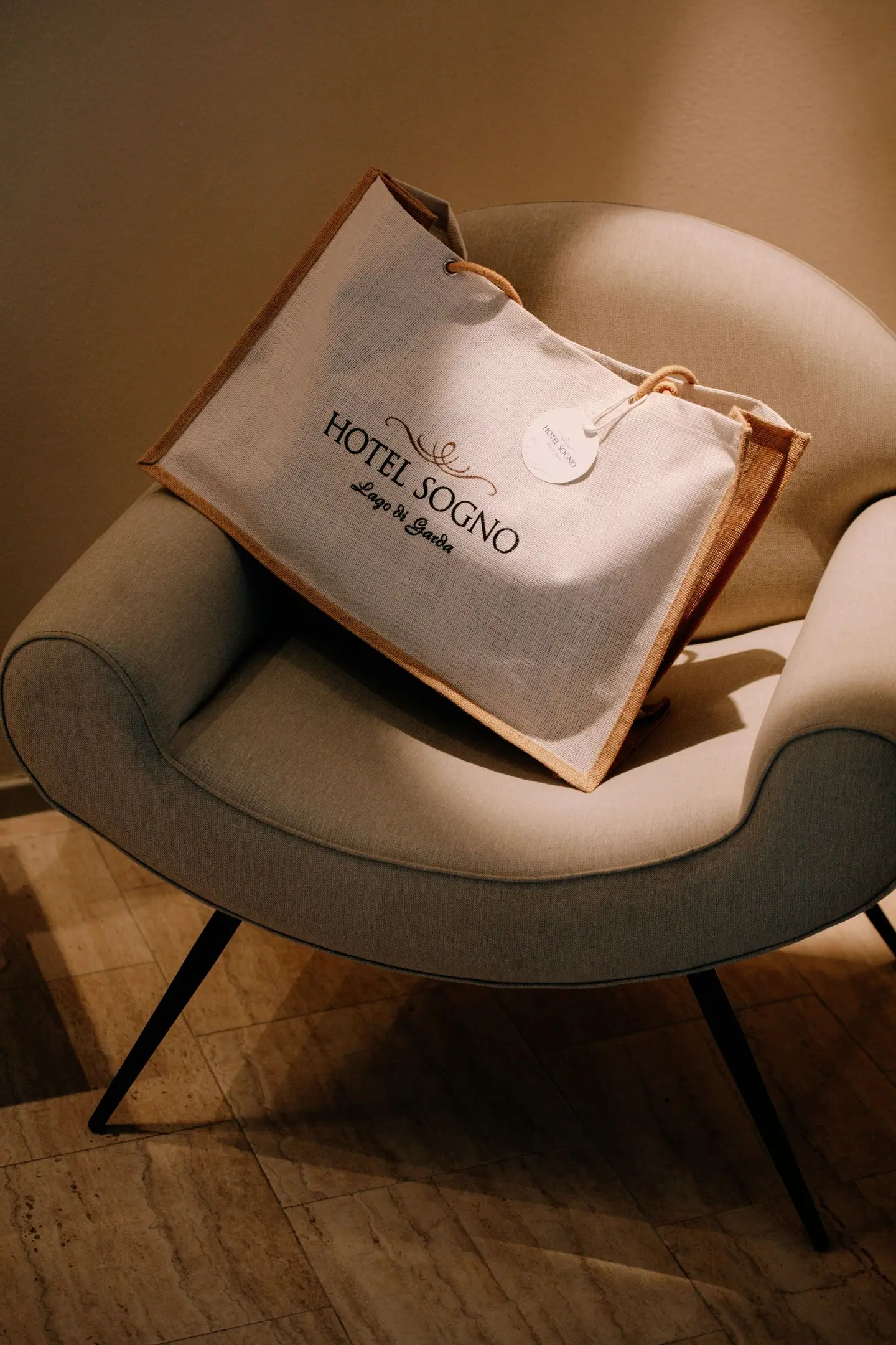 Borsa con la scritta Hotel Sogno appoggiata su una poltrona