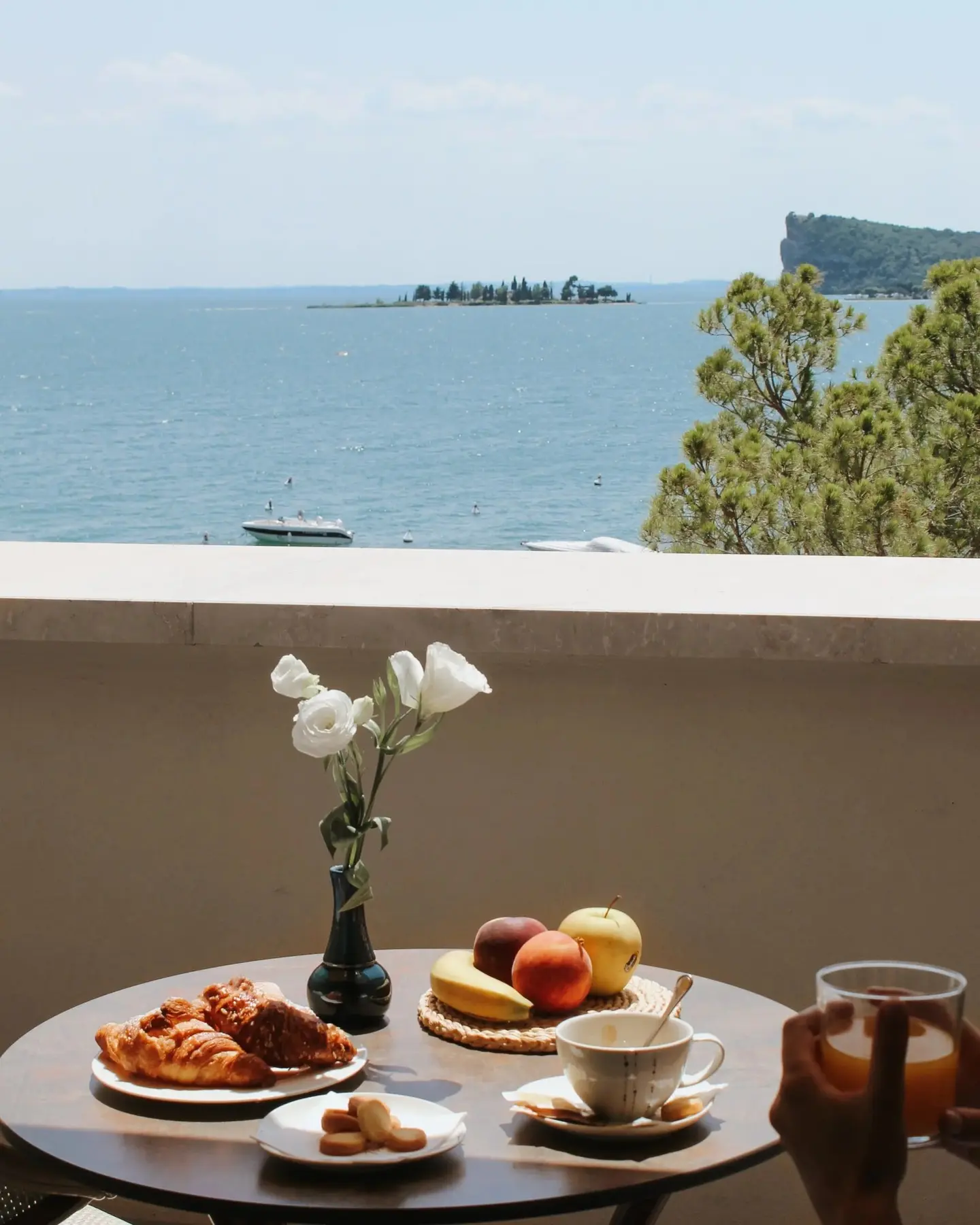 Colazione con cornetti e frutta su un balcone con vista lago