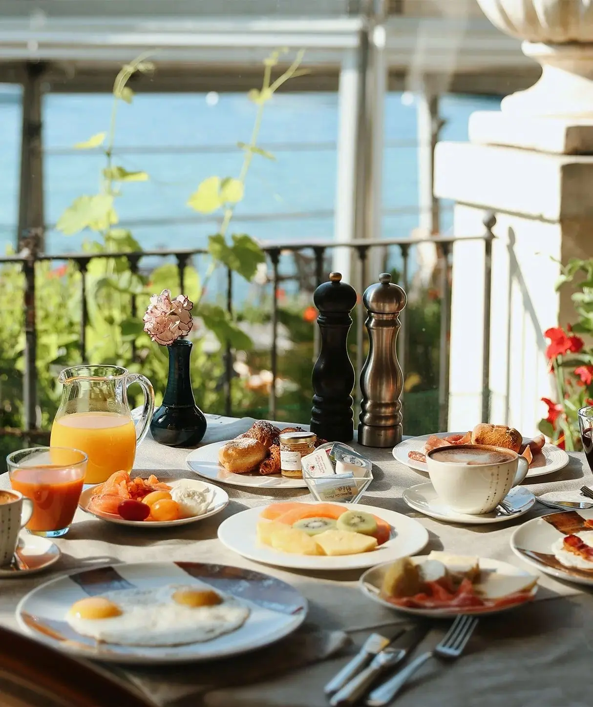Colazione servita con uova, frutta, dolci e succo d'arancia