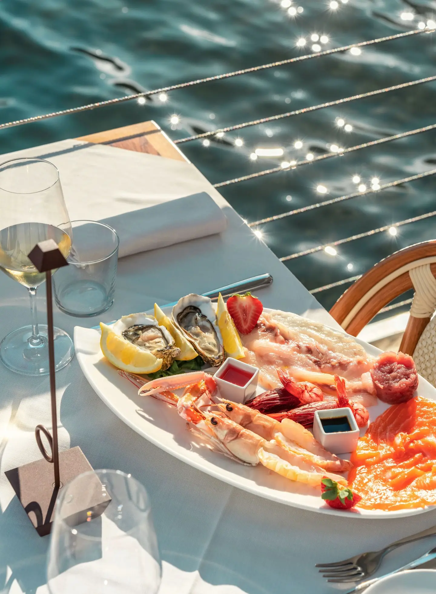 Piatto di crudo con ostriche, scampi, gamberi e salmone sulla terrazza