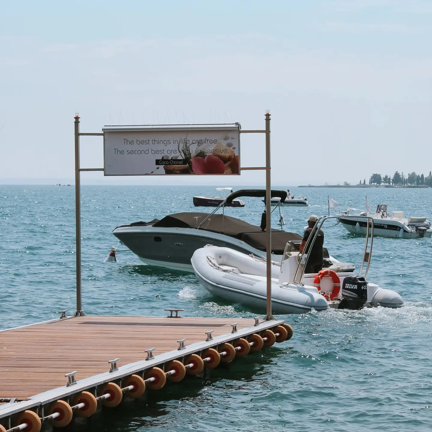Il pontile galleggiante con il gommone e un motoscafo in arrivo