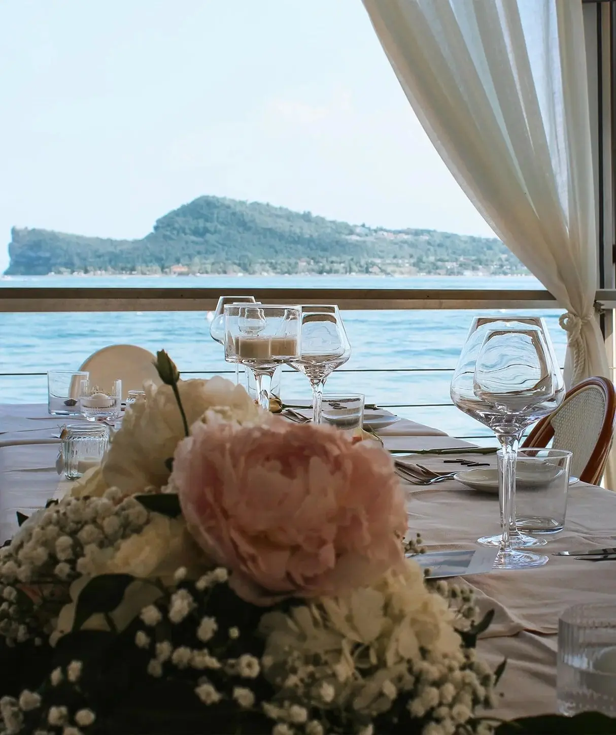 Tavolo apparecchiato con peonie sulla terrazza