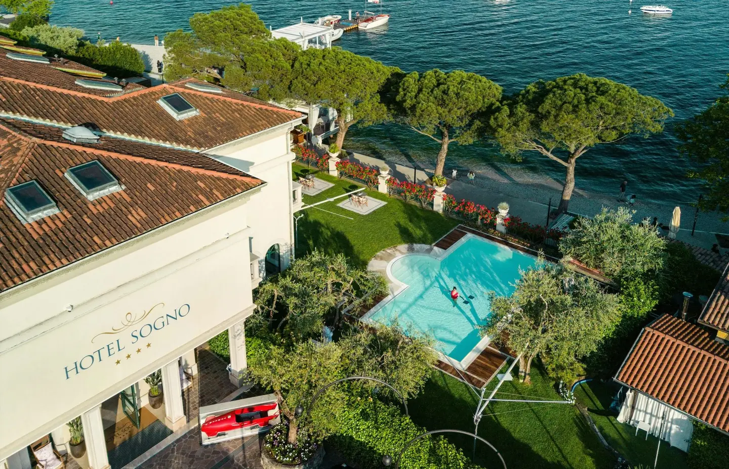 Veduta aerea dell'hotel con la piscina e il giardino sul lago