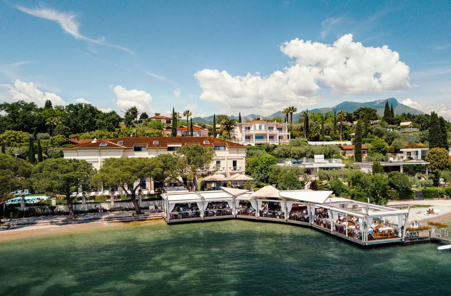 L'Hotel Sogno visto dal lago: la terrazza del ristorante sull'acqua e il giardino