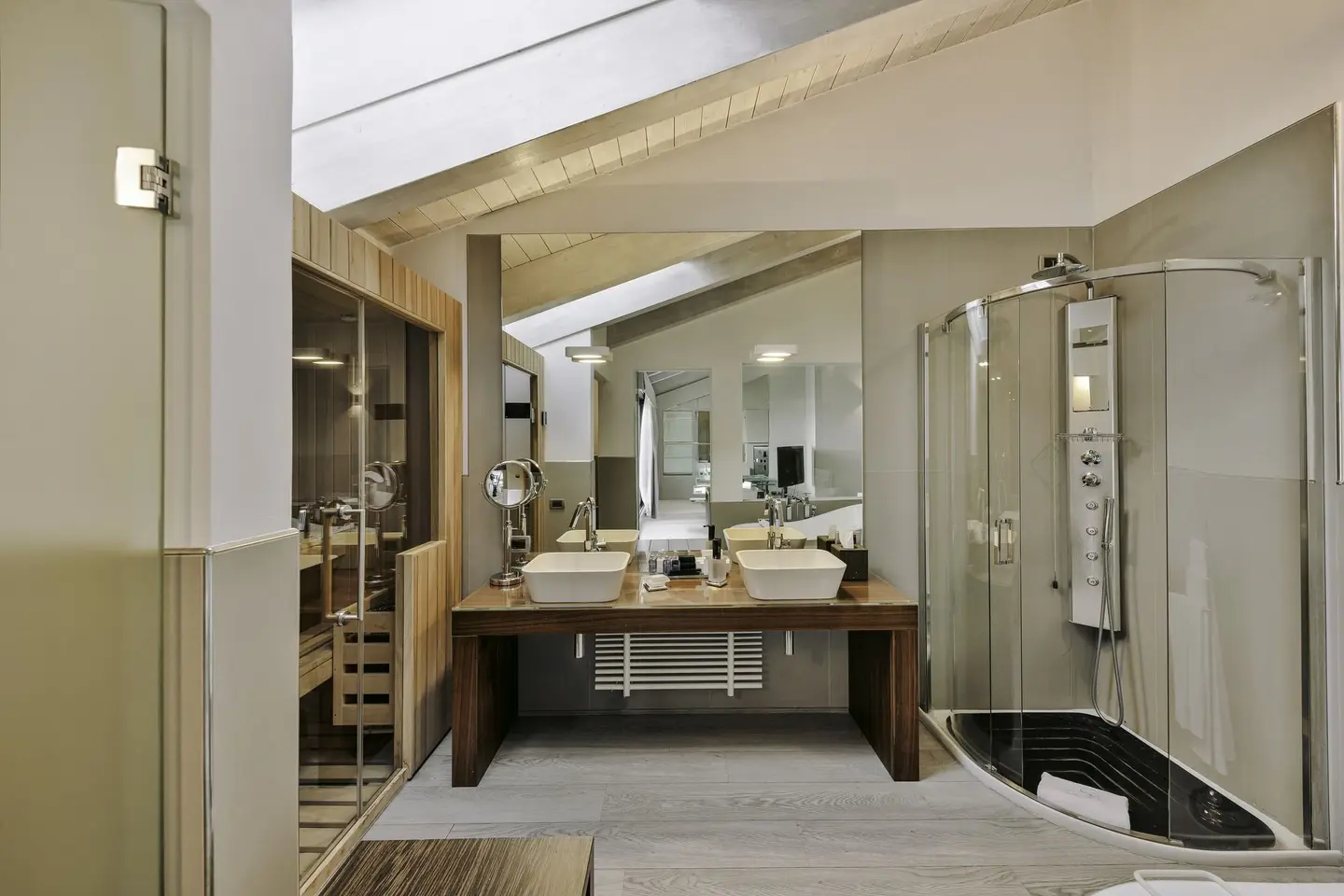 Il bagno di una suite con la doccia, la sauna e il doppio lavabo