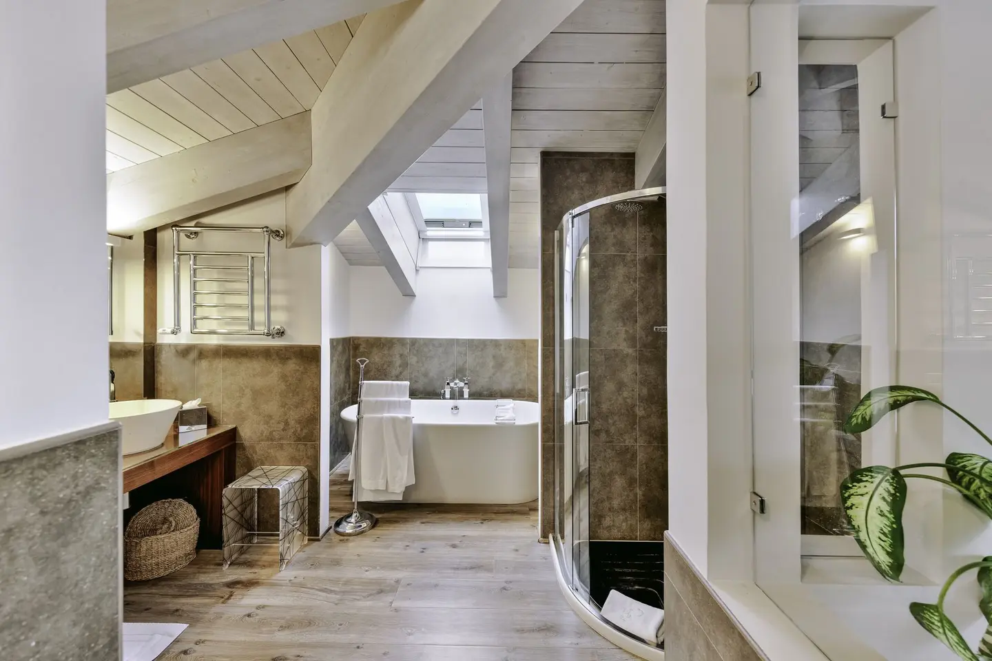 Il bagno mansardato di una suite, con la vasca e la doccia